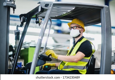 Man Worker Forklift Driver With Protective Mask Working In Industrial Factory Or Warehouse.