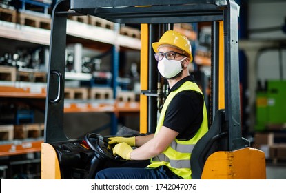 Man Worker Forklift Driver With Protective Mask Working In Industrial Factory Or Warehouse.