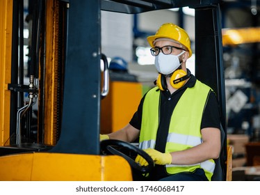 Man Worker Forklift Driver With Protective Mask Working In Industrial Factory Or Warehouse.