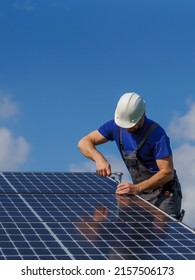 Man worker installing solar photovoltaic panels on roof, alternative energy concept. - Shutterstock ID 2157506173