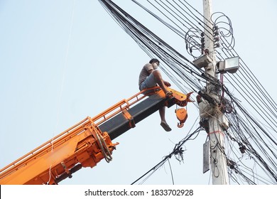 Man, Worker On Top Of Crane Tractor For Maintenance Electric Cables Without Safety Belt Is Risk Work. Concept Of Unsafe Work Place, Risk Work, Unsafe Work.                              