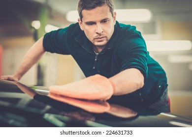 Man Worker Polishing Car On A Car Wash 