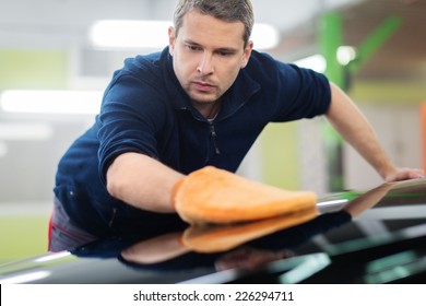 Man Worker Polishing Car On A Car Wash 