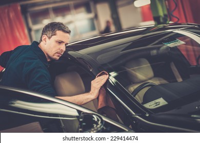 Man Worker Polishing Car On A Car Wash