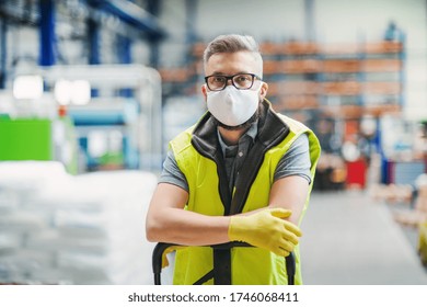 Man Worker With Protective Mask Standing In Industrial Factory Or Warehouse.