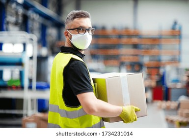 Man Worker With Protective Mask Working In Industrial Factory Or Warehouse.