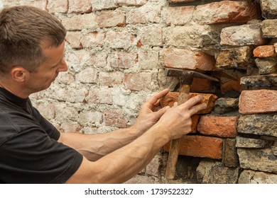  Ein Arbeiter, der alte Steinmauer rekonstruiert. Altbau, Reparatur
