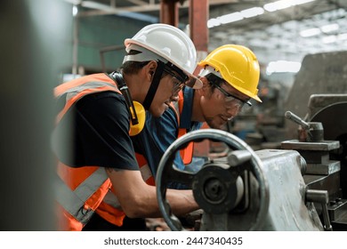 Man worker in safety helmet working on steel machine. Smart factory worker using machine in factory workshop. - Powered by Shutterstock