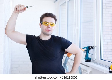 Man worker with screwdriver on balcony.