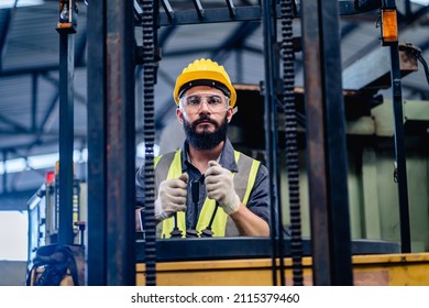 Man Worker Or Technician Mechanic In Safety Uniform Driving And Testing Forklift Truck After Repair In Machine Repair Factory.
