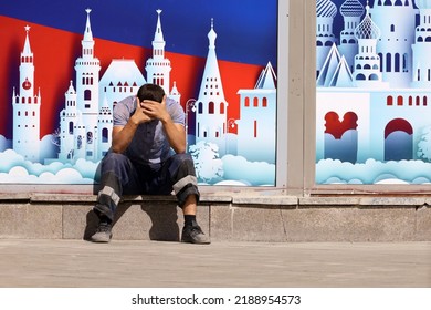 Man worker in uniform sitting on city street on background of decoration with Moscow landscape. Concept of unskilled labor in Russia and the problem of migrant workers - Shutterstock ID 2188954573