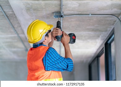 A Man Worker Use Electric Drill Screwdriver To Fix In Electric Junction Box In Renovate Home Building