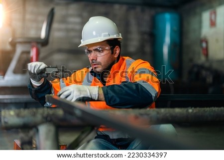 Man worker using Vernier Caliper measuring the thickness of the steel part in factory workshop. Factory worker concentrate working. Worker waring proper PPE during work in metal factory.