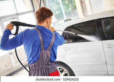 Man worker washing car on a car wash.