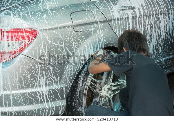Man\
worker washing car\'s alloy wheels on a car\
wash\
