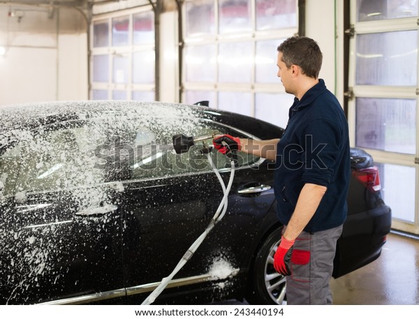 Man worker\
washing luxury car on a car wash\

