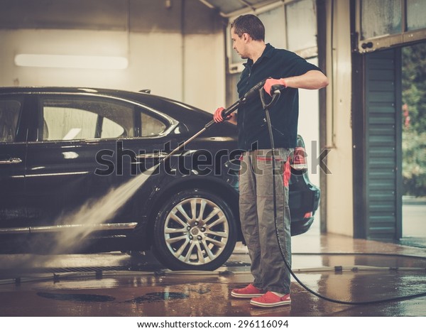 Man worker
washing luxury car on a car wash
