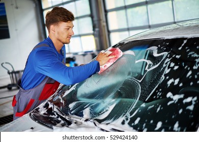 Man Worker Washing Windshield With Sponge On A Car Wash.