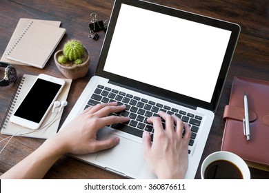 A man is working by using a laptop computer on vintage wooden table. Hand typing on a keyboard. - Powered by Shutterstock