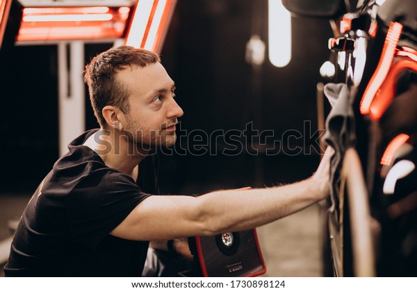 Man working at a\
car wash detailing station