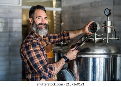 Man is working at craft beer factory. He is operating machinery in brewery. Small family business, production of craft beer. - Powered by Shutterstock