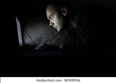 man working in the dark on their computers