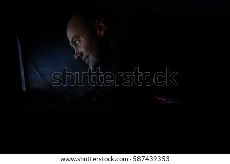 man working in the dark on their computers