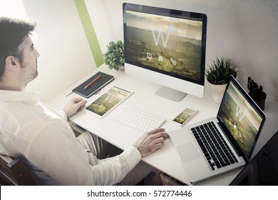 Man Working With Devices With Responsive Theme Website. All Screen Graphics Are Made Up.