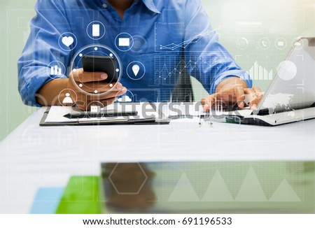 Man working with digital tablet, laptop and modern computer interface as technology concept in his office.