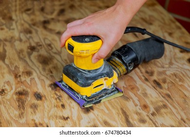 A man working with electrical sanding machine