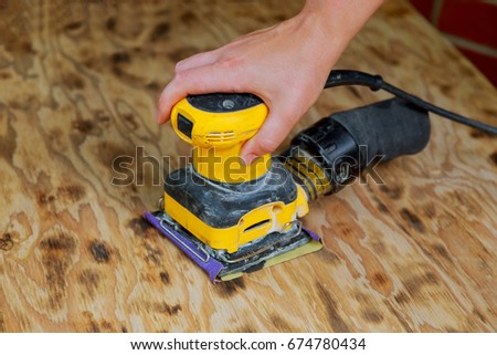 A man working with electrical sanding machine