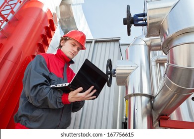 Man working in a factory, controls the operation of devices in a Heating Plant or Refinery. Please see my other photo and videos with the same theme.