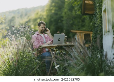 Man working in the garden on laptop, phone calling. Businessman working remotely from outdoor homeoffice, thinking about new business or creative idea. - Powered by Shutterstock