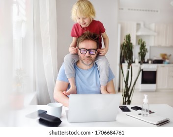 Mann, der während der Quarantäne von zu Hause aus arbeitet. Der kleine Sohn sitzt auf seinen Schultern, zieht Ohren und lenkt ab. Online arbeiten und Kinder gleichzeitig erziehen. Ausgeschiedene Eltern mit hyperaktivem Kind.
