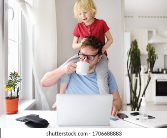 Mann, der während der Quarantäne von zu Hause aus arbeitet. Kleiner Sohn, der auf seinen Schultern sitzt, zieht Haare und lenkt ab. Online arbeiten und Kinder gleichzeitig erziehen. Ausgeschiedene Eltern mit hyperaktivem Kind.