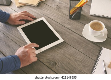 Man Working In A Home Office. Men Hand Clicks On The Tablet Screen On Wooden Table. Concept Man Working From Home Using Tablet Computer Or Working Outside The Office