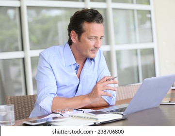 Man Working From Home On Laptop Computer