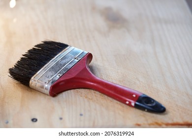 Man Working At Home Varnishing A Wooden Chair With A Brush And Varnish. Man Composing His Chair Himself.