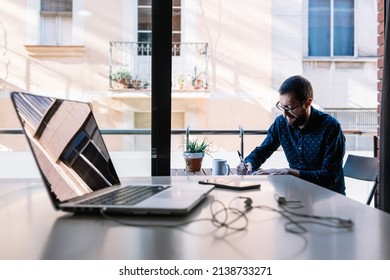 Man working at home and writing down his plan of action - Shutterstock ID 2138733271