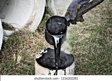 a man working with hot tar - Shutterstock ID 1156202281