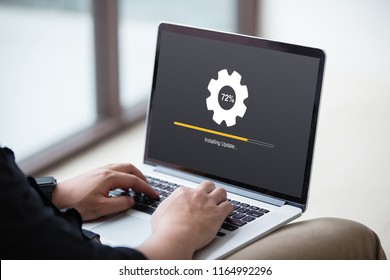 Man working and Installing update process with gearbox percentage progress and loading bar on laptop / computer screen at office