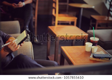 Man working with iPad in the coffee shop. Co working space free wifi at Starbucks coffee.