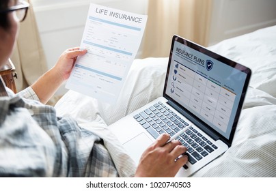 A man working with a laptop in bed