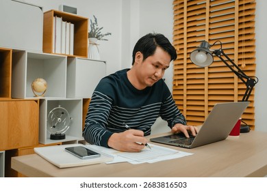 man working with laptop computer and document at home office