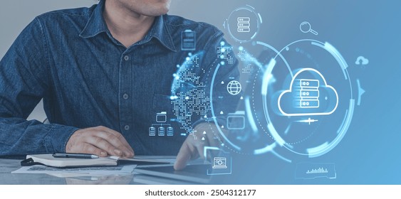 Man working in laptop in office room, cloud service hologram icons, files sync and data transfer. Concept of system backup, online database and synchronization - Powered by Shutterstock