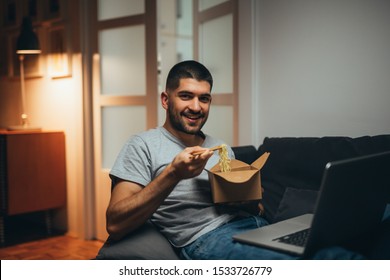 Man Working Late On Laptop Eating Chinese Food At His Home