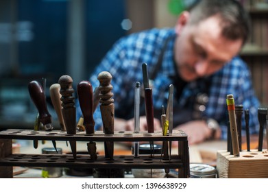 Man working with leather textile at a workshop. Craftman cutting leather. Concept of handmade craft production of leather goods. - Powered by Shutterstock