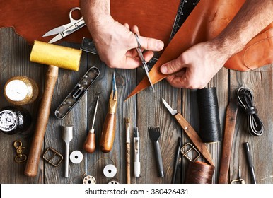 Man working with leather using crafting DIY tools 