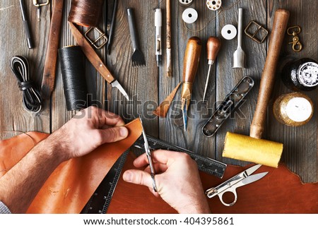 Man working with leather using crafting DIY tools 