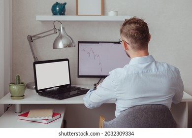 Man Working, Looking At Technical Charts On Pc And Laptop With Blank Screen. Mockup, Back View.